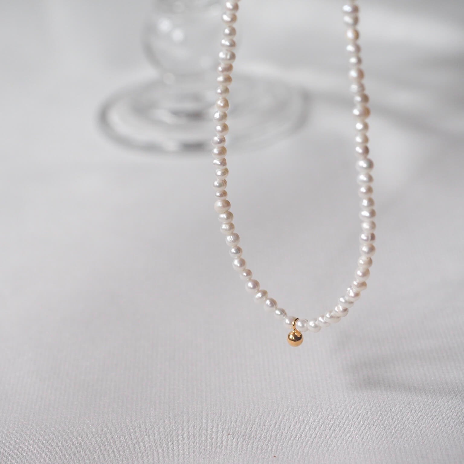 white-pearl-necklace-adorned-with-gold-charm.jpg